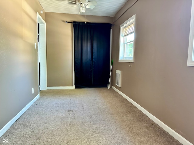 carpeted empty room featuring ceiling fan