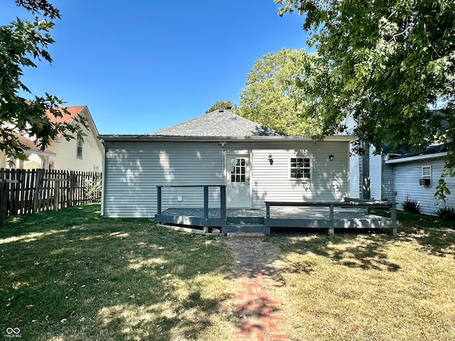 rear view of house with a wooden deck and a yard