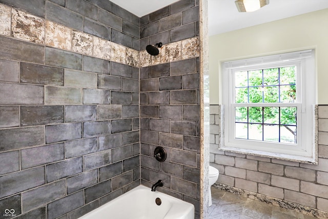 bathroom with tiled shower / bath and toilet