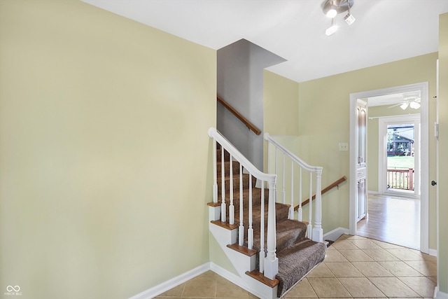 stairs featuring ceiling fan and tile patterned flooring