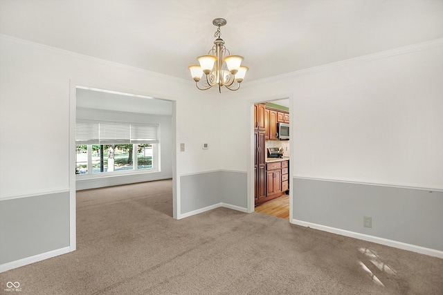 carpeted spare room with crown molding and a notable chandelier