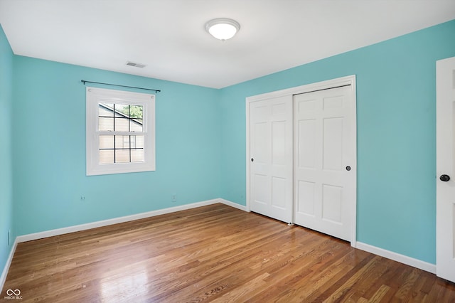 unfurnished bedroom featuring wood-type flooring and a closet