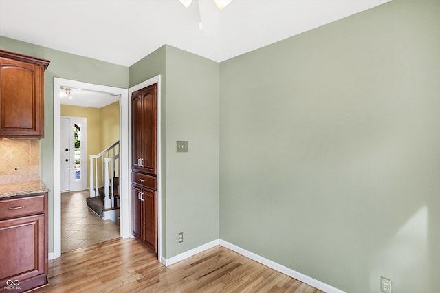 kitchen with tasteful backsplash, light stone countertops, and light hardwood / wood-style floors