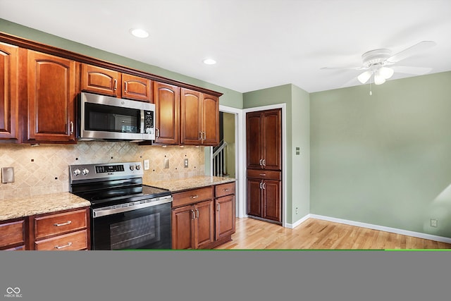 kitchen with appliances with stainless steel finishes, tasteful backsplash, light hardwood / wood-style floors, ceiling fan, and light stone counters