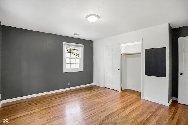 unfurnished bedroom featuring light hardwood / wood-style flooring and a closet