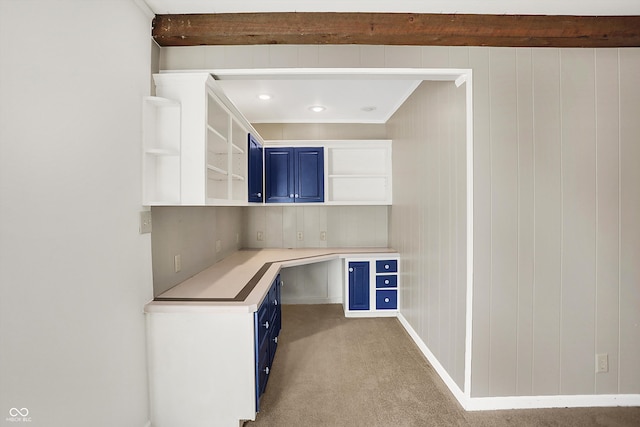 unfurnished office with light colored carpet, ornamental molding, and beamed ceiling