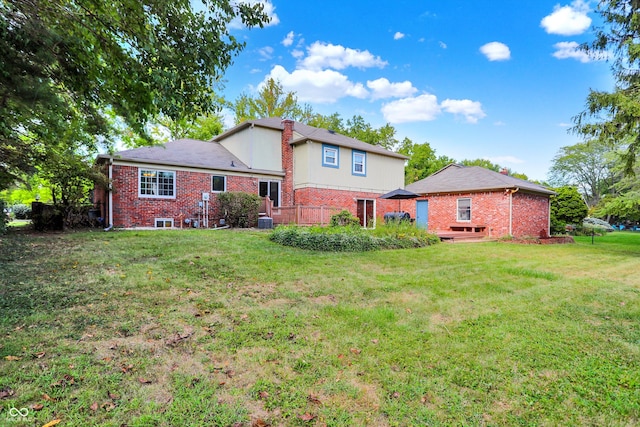 rear view of property with a wooden deck and a lawn