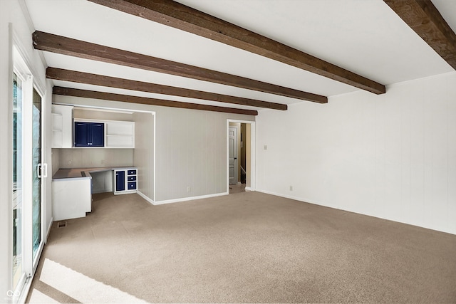 unfurnished living room featuring light colored carpet and beam ceiling