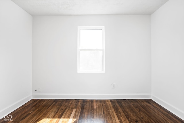 unfurnished room with a textured ceiling and dark hardwood / wood-style flooring