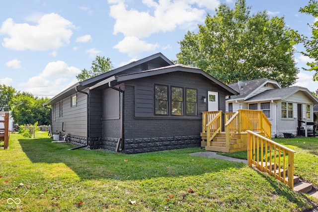 bungalow-style home featuring a wooden deck and a front lawn