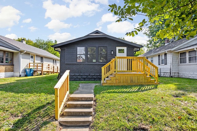 rear view of house featuring a yard, brick siding, and stairway