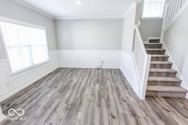 unfurnished room featuring crown molding and light wood-type flooring