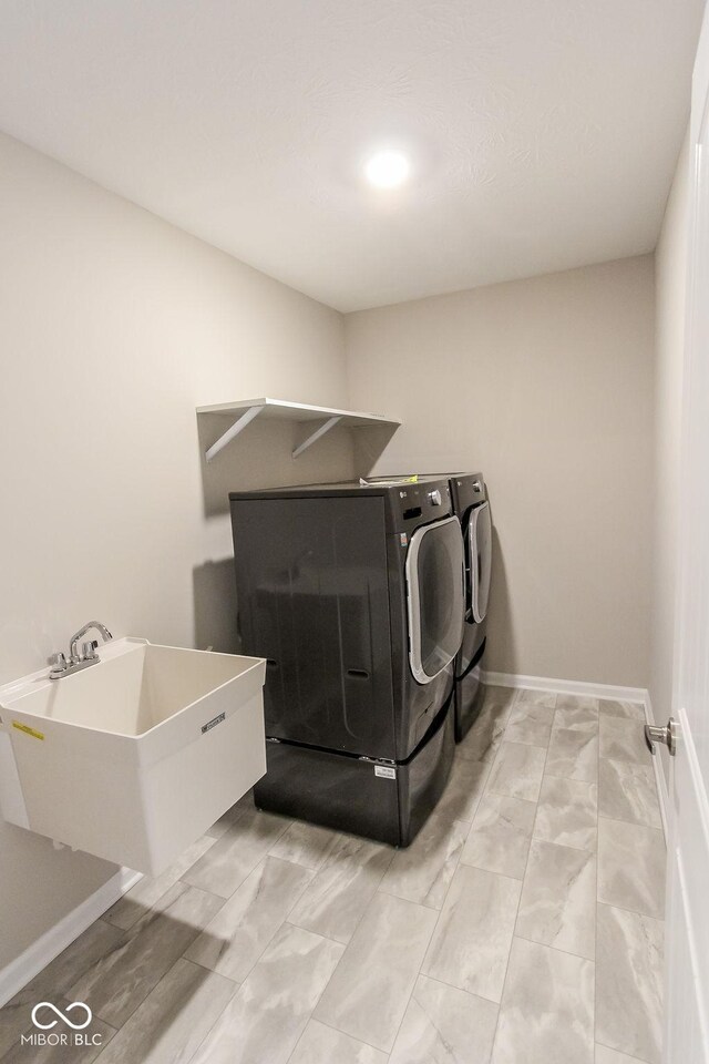 clothes washing area featuring washing machine and clothes dryer and sink