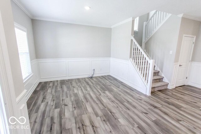 spare room with crown molding, a healthy amount of sunlight, and light hardwood / wood-style flooring