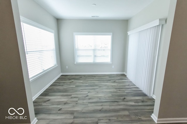 spare room featuring a wealth of natural light and hardwood / wood-style floors