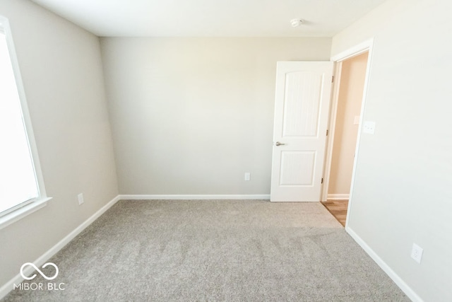 unfurnished room featuring light carpet