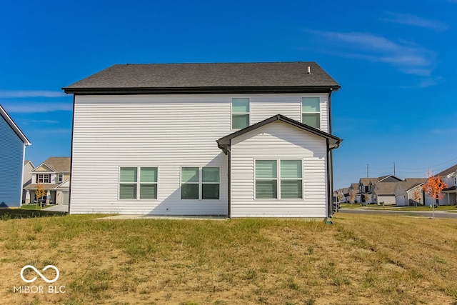 rear view of house featuring a lawn