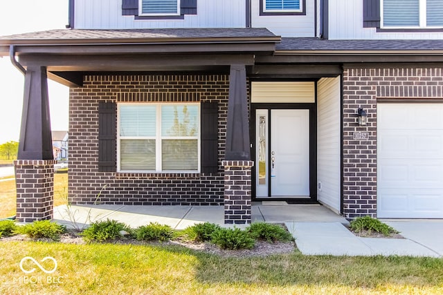 doorway to property with a garage and covered porch