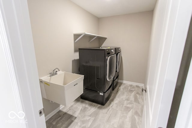 washroom with washer and dryer and sink