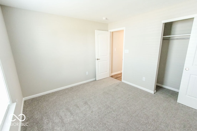 unfurnished bedroom with light colored carpet and a closet