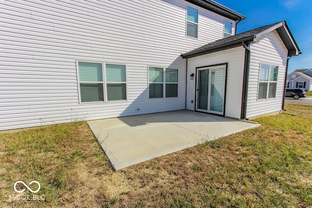 rear view of house featuring a lawn and a patio area