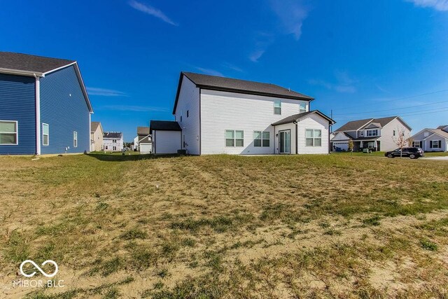 rear view of property with a yard