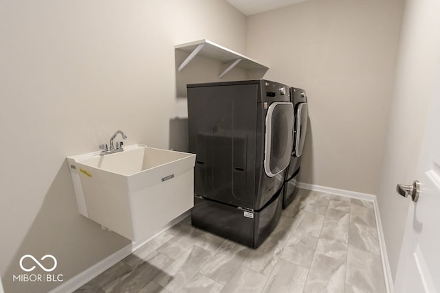 clothes washing area featuring sink and independent washer and dryer