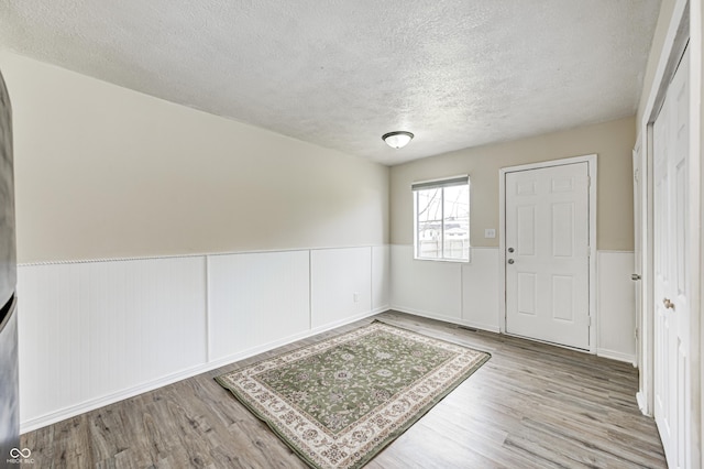 120 Hugo St, Indianapolis, IN 46229 - entrance foyer featuring a wainscoted wall, a textured ceiling, and wood finished floors