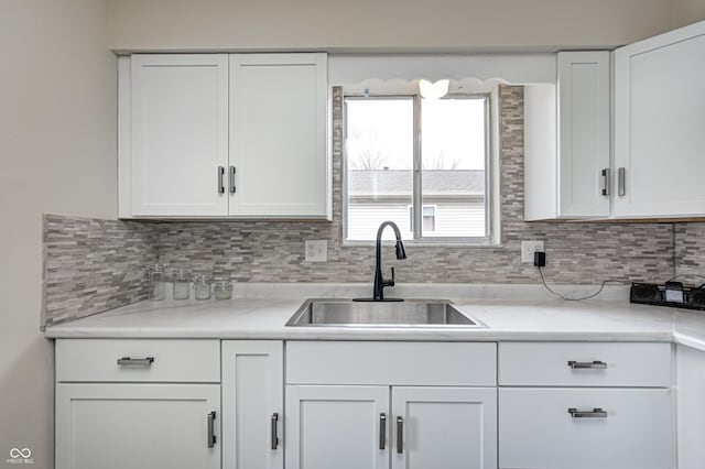 120 Hugo St, Indianapolis, IN 46229 - kitchen featuring white cabinets, tasteful backsplash, and a sink