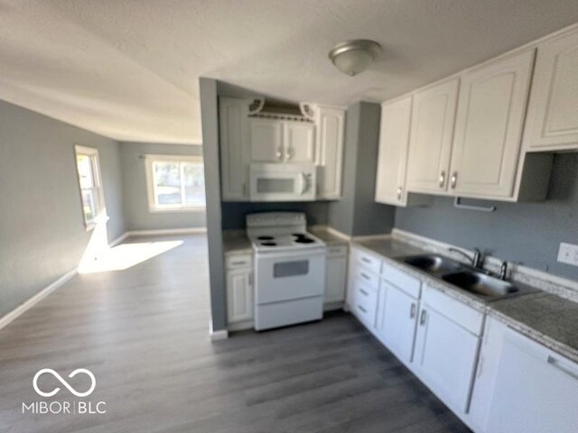 kitchen featuring dark hardwood / wood-style flooring, sink, white appliances, and white cabinetry