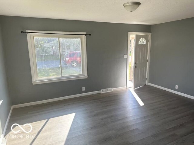 interior space with a textured ceiling and dark hardwood / wood-style floors