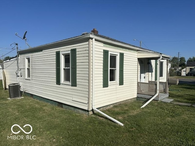 view of home's exterior with a yard, central AC, and a chimney