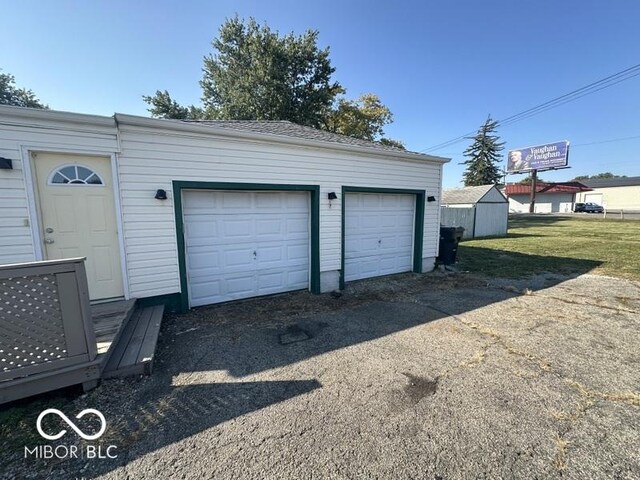 garage featuring a lawn and wooden walls