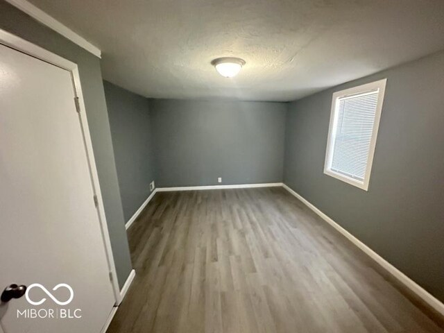 spare room featuring a textured ceiling and light wood-type flooring