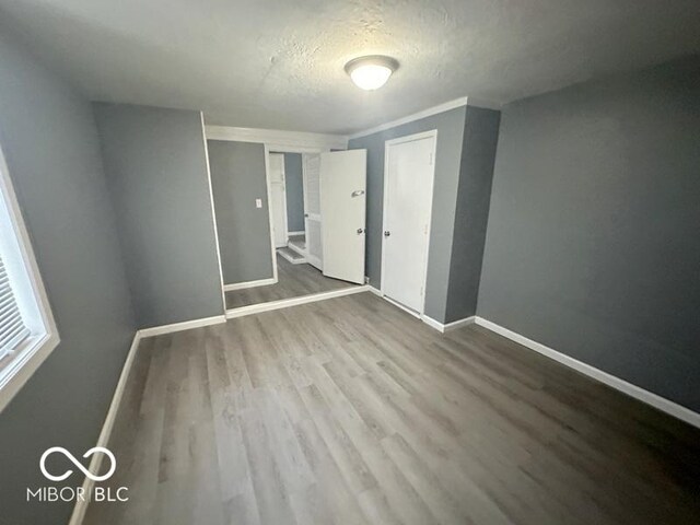 unfurnished bedroom featuring a closet, wood-type flooring, and a textured ceiling