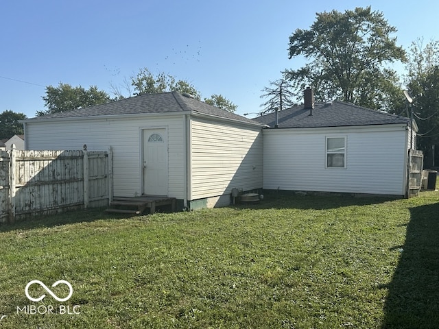 rear view of house with a lawn and central AC