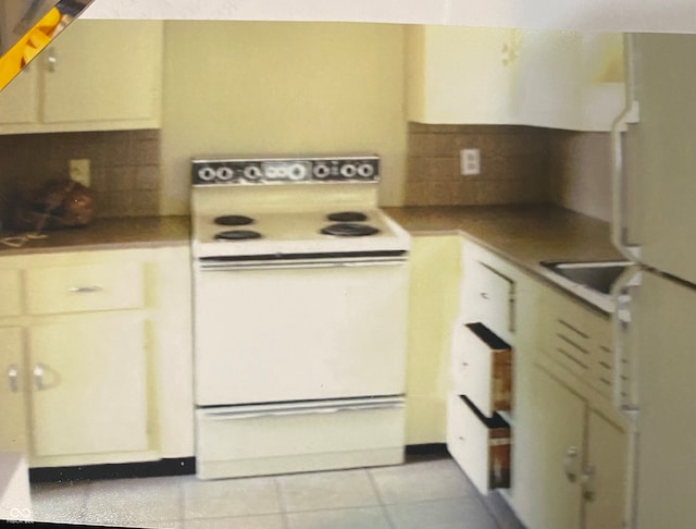 kitchen with decorative backsplash, white appliances, and light tile patterned flooring