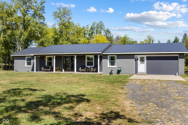 single story home featuring a porch, a garage, and a front yard