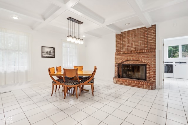 dining room with light tile patterned floors, coffered ceiling, a fireplace, and separate washer and dryer