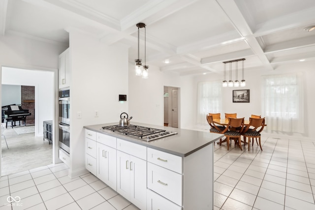 kitchen featuring white cabinets, light tile patterned floors, beamed ceiling, stainless steel appliances, and decorative light fixtures