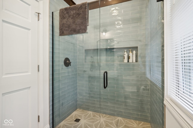 bathroom with a shower with door