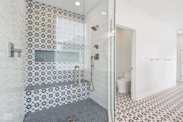 bathroom featuring tile patterned flooring, toilet, and a shower with shower door