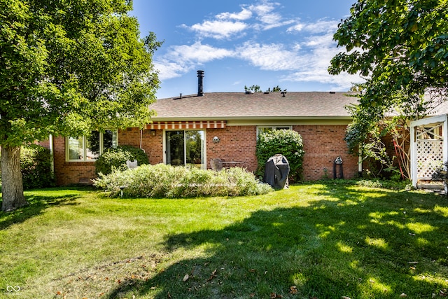 rear view of house featuring a yard