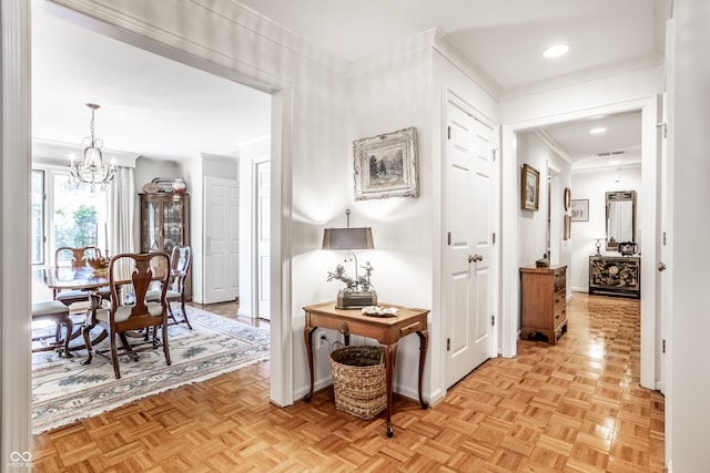 hall with light parquet flooring and an inviting chandelier