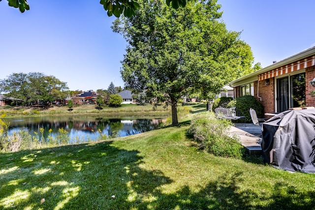 view of yard with a water view and a patio area