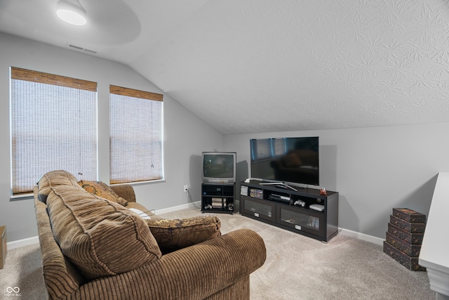 living room with carpet floors, a textured ceiling, and lofted ceiling