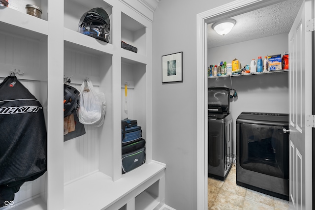 mudroom featuring a textured ceiling and washer and clothes dryer