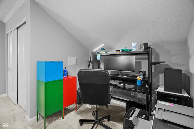 home office featuring lofted ceiling, a textured ceiling, and light colored carpet