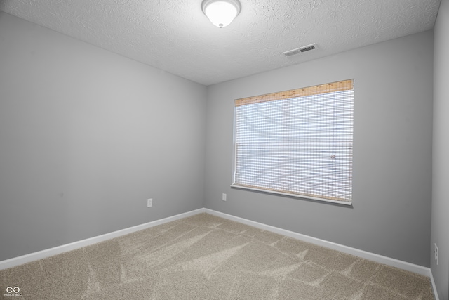 empty room with a textured ceiling and carpet