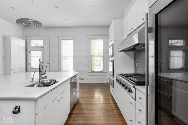 kitchen with a kitchen island with sink, dark hardwood / wood-style flooring, sink, stainless steel appliances, and white cabinetry